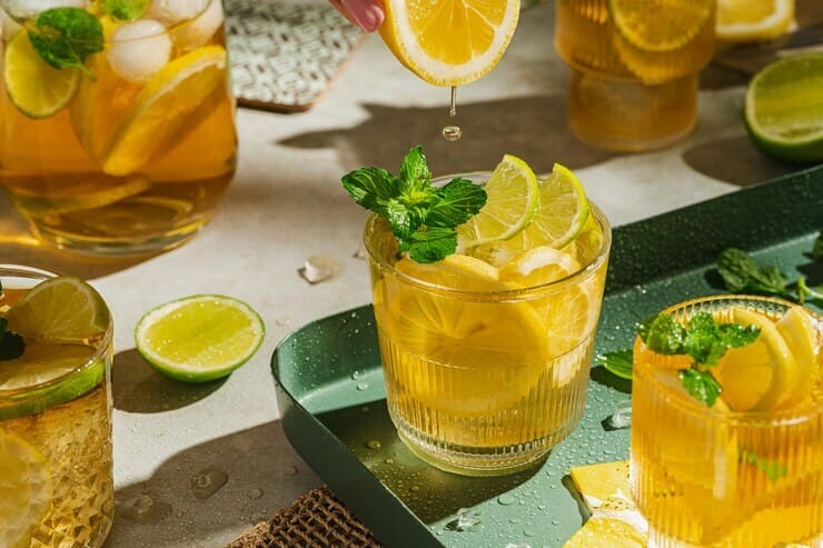 Bicchieri di tè freddo al limone accanto a una caraffa